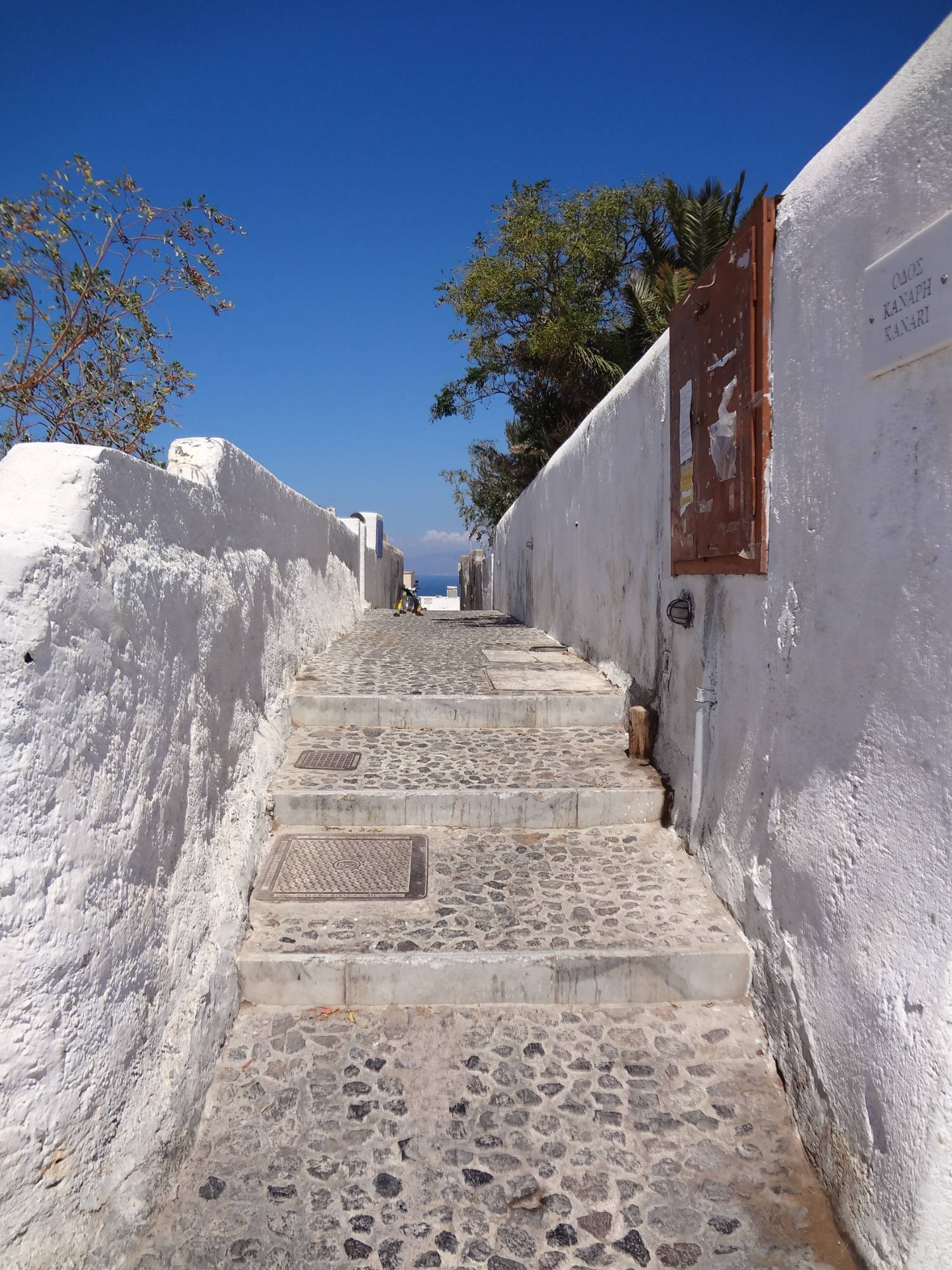 A whitewashed alley of steps under a blue sky